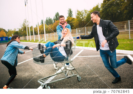 Group of four young diverse friends in jeanse outfit look carefree, young and happy on city's streets 70762845