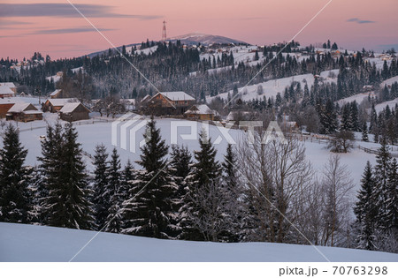 Small and quiet alpine village and winter sunrise snowy mountains around, Voronenko, Carpathian, Ukraine. 70763298