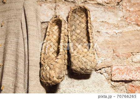 Vintage Russian bast shoes hang on brick wall 70766265