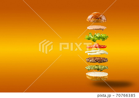 Floating burger ingredients on orange background 70766385