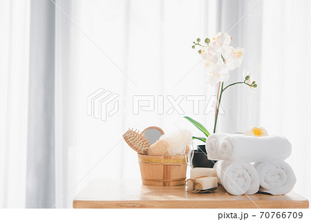 Spa products with white towels,soap,luffa scrub,comb and beautiful orchid flower in clean white room 70766709