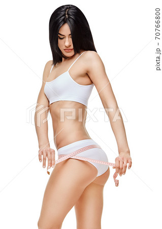Slim tanned woman's body isolated on white background - waist measurement 70766800