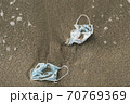Medical face masks discarded on sea shore,covid19 pandemic disease pollution 70769369