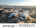 Medical face mask discarded trash on sandy beach,covid19 pandemic pollution  70769372