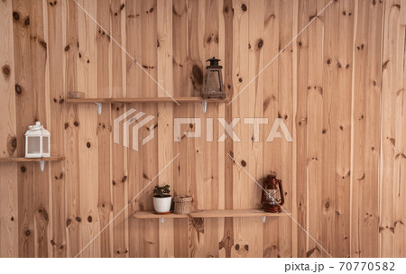 Old lamps or Retro lantern and pot with ivy plant on shelves at wooden wall. Front view. Abstract background or wallpaper Old lamps or Retro lantern and pot with ivy plant on shelves at wooden wall. Front view. Abstract background or wallpaper 70770582