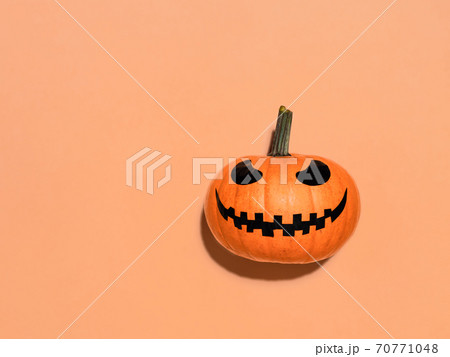 Halloween pumpkin in hand on orange background. 70771048