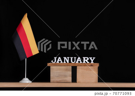 Wooden calendar of January with German flag on black background. Holidays of German in January. 70771093