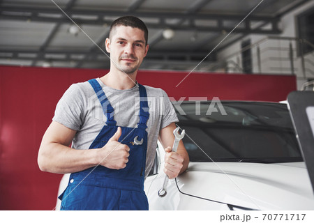 Hand of car mechanic with wrench. Auto repair garage 70771717