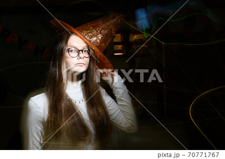 A beam of light flashes a girl with orange Halloween hat A beam of light flashes a girl with orange Halloween hat 70771767