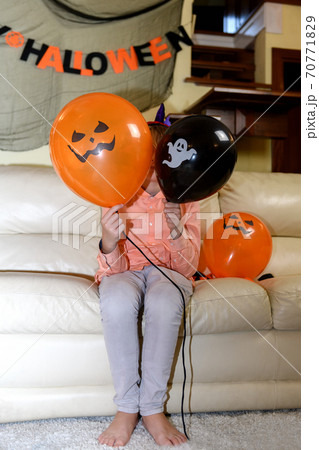 a boy is having fun and playing with orange and black Halloween baloons a boy is having fun and playing with orange and black Halloween baloons 70771829