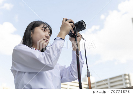 屋上でカメラを構えている女子高生の写真素材