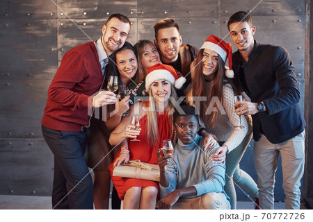 New Year is coming! Group of cheerful young multiethnic people in Santa hats on the party, posing emotional lifestyle people concept New Year is coming! Group of cheerful young multiethnic people in Santa hats on the party, posing emotional lifestyle people concept 70772726