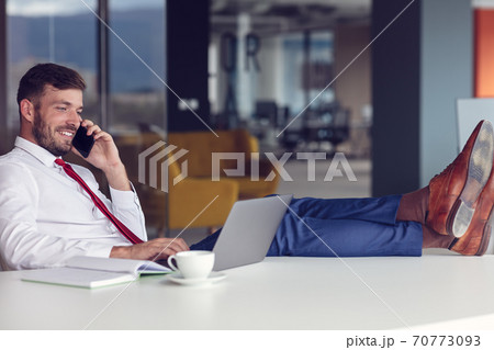 Businessman With Laptop And Smartphone At Office Businessman With Laptop And Smartphone At Office 70773093
