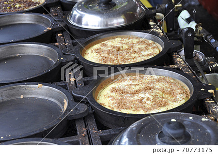 Apam balik or Malaysian Peanut Pancake turnover.  Flour pancake stuffed with sugar and corn topping. Cooked using the hot pan. Famous street food in Malaysia.  70773175