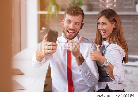 beautiful business workers working together using laptop at the office doing happy thumbs up gesture with hand. beautiful business workers working together using laptop at the office doing happy thumbs up gesture with hand. 70773494