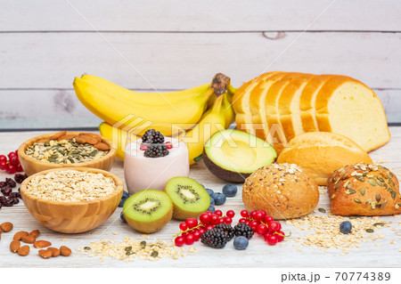 Group Fruits Breakfast with bread Whole grains and nuts, yogurt mix with Cherry , banana, avocado in the wooden table. Breakfast for Health and Diet concept 70774389