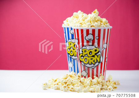 Baked Butter Popcorn into a red and blue striped paper cup, roasted Butter Corn Kernels Mixed with natural salt, Appetizers in the cinema or party Baked Butter Popcorn into a red and blue striped paper cup, roasted Butter Corn Kernels Mixed with natural salt, Appetizers in the cinema or party 70775508