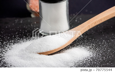 White sea salt for cooking food in Small glass bottles and wooden spoons on a stone tray background. White sea salt for cooking food in Small glass bottles and wooden spoons on a stone tray background. 70775544
