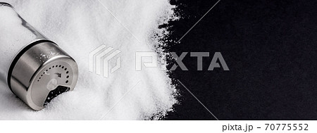 White sea salt for cooking in a small glass bottle. On the salt background, write stop. Concept for health White sea salt for cooking in a small glass bottle. On the salt background, write stop. Concept for health 70775552