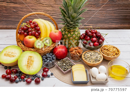 Group Nuts put on the bowl and fruit is banana,pineapple and grape is food healthy on the wooden table background Group Nuts put on the bowl and fruit is banana,pineapple and grape is food healthy on the wooden table background 70775597
