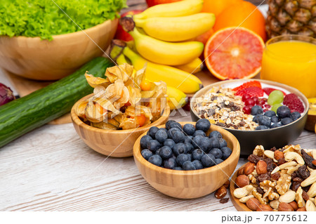 Group Fruits Breakfast mixed vegetables with salad bowl, nuts bowl, strawberry, banana, and pineapple, orange juice,  vitamin c in food  nature for health and diet in the top view on the wood table. 70775612
