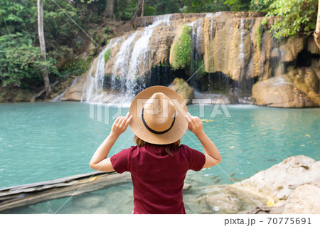 Rear view of young woman traveling in Erawan waterfall in Kanchanaburi Thailand 70775691