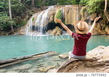 Rear view of young woman traveling in Erawan waterfall in Kanchanaburi Thailand 70775692