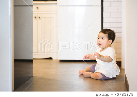 キッチンで座っている赤ちゃんの写真素材