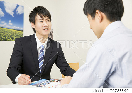 説明をする旅行代理店の男性スタッフ 70783396