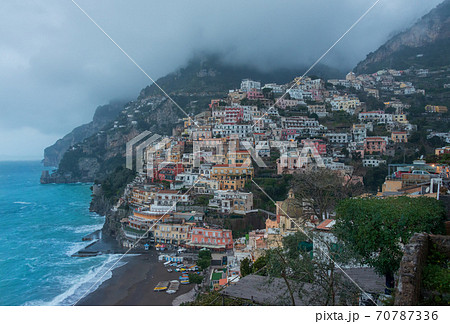 A high angle view of Positano with colorful buildings along the hillside. The morning atmosphere has fog over the city. 70787336