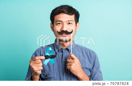 handsome man posing he holding a light blue ribbon and mustache handsome man posing he holding a light blue ribbon and mustache 70787828