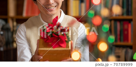 クリスマス プレゼントを彼女に渡そうとする若い男性 バナーサイズ クリスマス プレゼントを彼女に渡そうとする若い男性 バナーサイズ 70789999