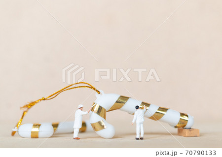 Miniature people,  Worker team painting a Christmas decoration 70790133