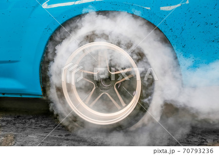 Drag racing car burns rubber off its tires in preparation for the race 70793236