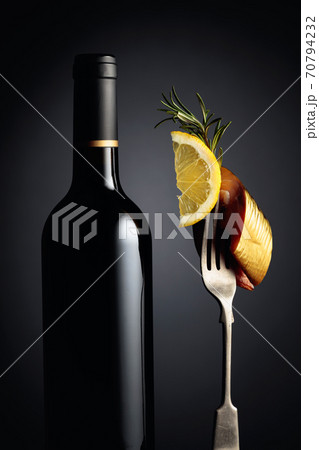 Bottle of wine and smoked mackerel with lemon slice. Bottle of wine and smoked mackerel with lemon slice. 70794232