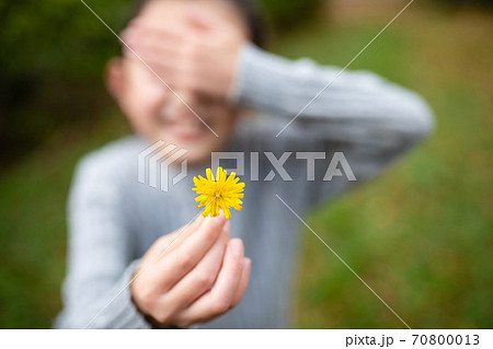 照れながら花を差し出す少女 70800013