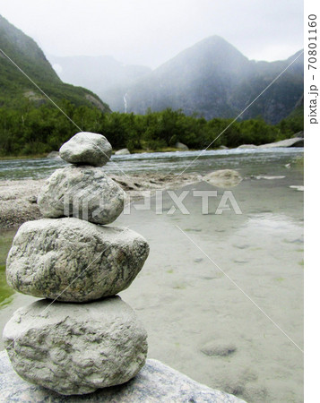 A stone mound in the background with a lake and mountains 70801160