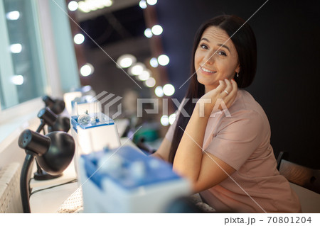 Beautiful woman tailor with long dark hair completing work with sewing machine at workplace Beautiful woman tailor with long dark hair completing work with sewing machine at workplace 70801204