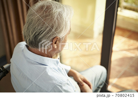 high angle rear view of a lonely asian old man sitting in wheel chair in nursing home 70802415