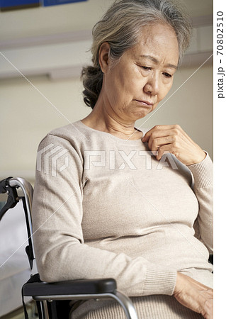 sad and depressed asian old woman sitting alone in wheel chair with head down in nursing home sad and depressed asian old woman sitting alone in wheel chair with head down in nursing home 70802510