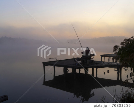 fisherman on Jenoi pond near Diosjeno, Northern Hungary 70803259