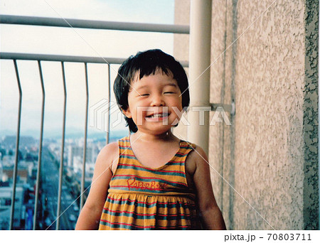 昔のフィルム写真　ベランダの笑顔の女の子 70803711