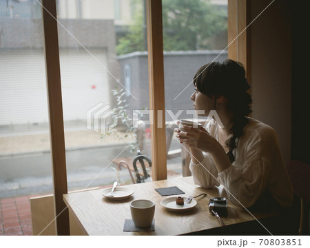 カフェでコーヒーカップを持つ女性 カフェでコーヒーカップを持つ女性 70803851