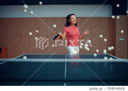Woman among flying ping pong balls, table tennis Woman among flying ping pong balls, table tennis 70804668