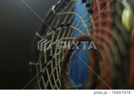 The dream catcher hangs from the lamp.  70807978