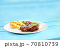 Chicken steak with grilled bread and salad plate on blue table. 70810739