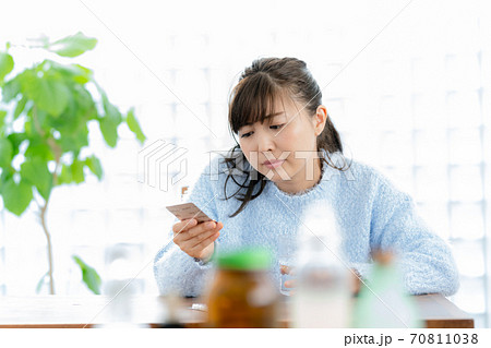 体調不良で薬を飲む女性 70811038