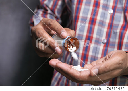 Close up of man hand taking medicine  70811423