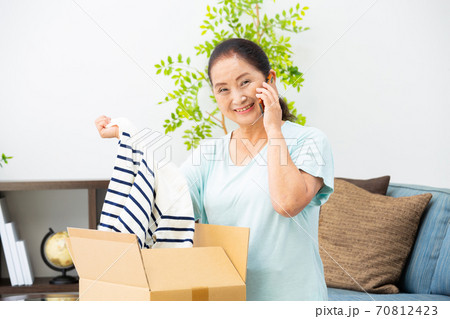荷物が届く お礼の電話をかけるシニア女性 荷物が届く お礼の電話をかけるシニア女性 70812423