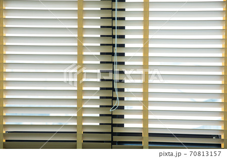 Wooden blinds with daylight illuminating through 70813157